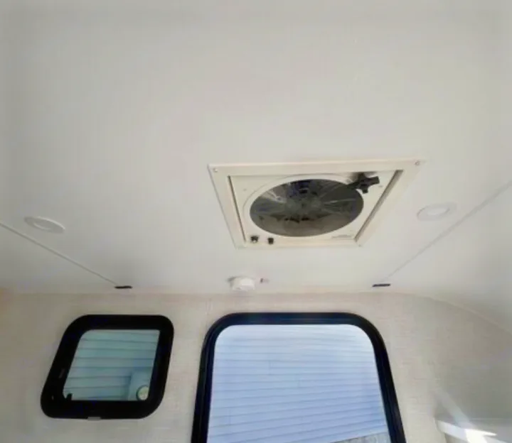 RV rental's bright interior: ceiling fan, recessed lights, & windows looking out to siding.. Bontrager Outdoors 12RAD 2025