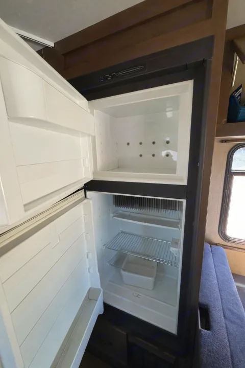 A clean, open refrigerator and freezer in an RV, ready for your next rv rental adventure.. Thor Majestic 2018