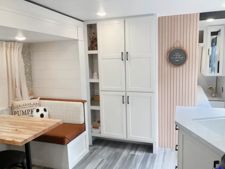 Modern RV rental interior with white pantry, cozy dining nook, and chic pink fluted accent wall. Perfect tiny home style.. Jayco Jay Flight SLX 2025