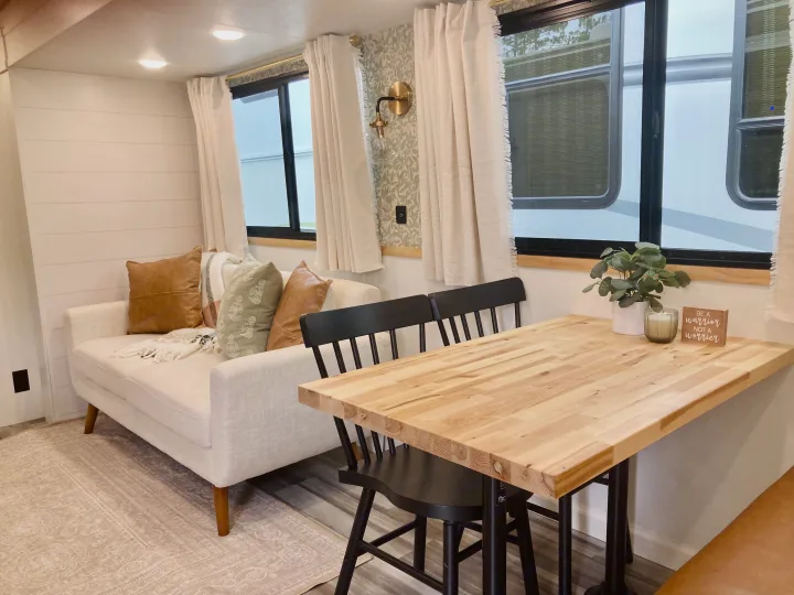 Cozy RV rental interior featuring a modern living space with couch and a dining area with a wooden table.. Jayco Jay Flight SLX 2025