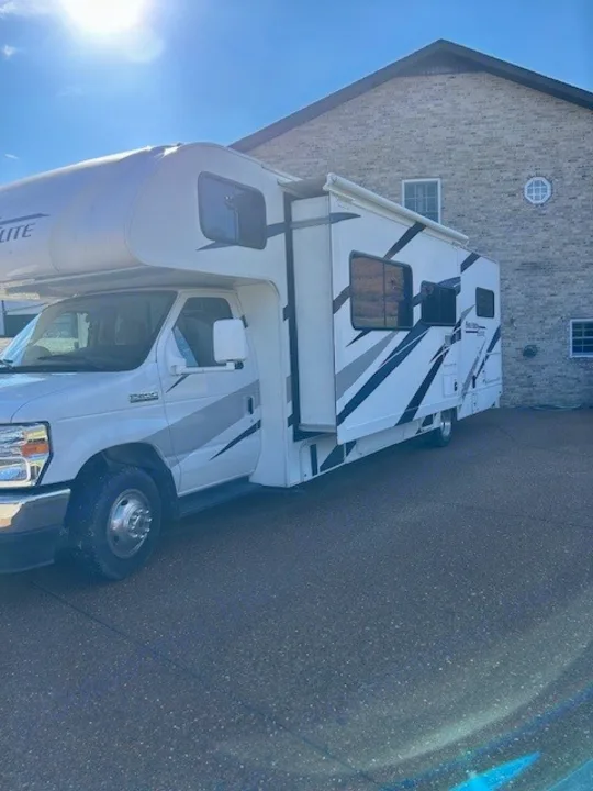 Spacious Class C rv rental with an extended slide-out, parked outdoors. Perfect for family road trips & adventures.. Thor Freedom Elite 2021