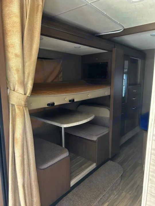 Inside this rv rental, find a compact bunk bed over a dinette, with a TV & storage cabinetry. Ready for your trip!. Thor Freedom Elite 2021