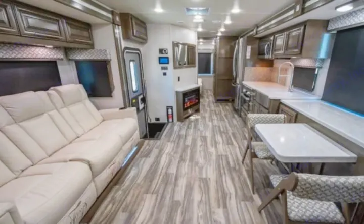 This spacious, modern RV rental interior features a comfy sofa, full kitchen, dining area, and fireplace, perfect for travel.. Georgetown GT7 2022