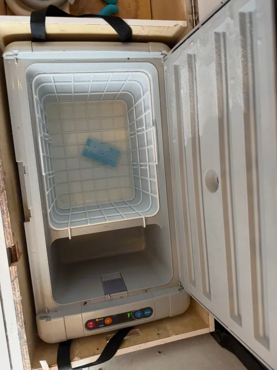 Open, frosty portable fridge/freezer for rv rental, showing empty basket, ice pack, and control panel.. Gmc Ram Promaster 2018
