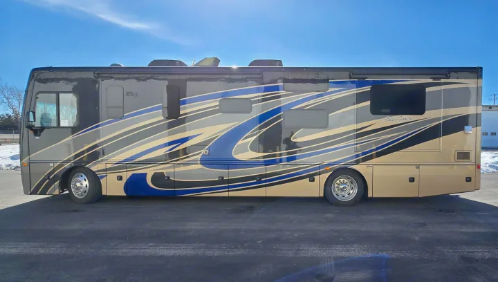 This large motorhome, ideal for RV rental, showcases a striking black, blue, gray, and gold design.. Fleetwood Pace Arrow 35E 2019