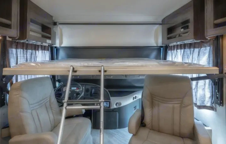 RV rental interior: cozy drop-down bunk bed above driver's cab, plush captain's chairs, and storage. Ready for adventure.. Fleetwood Pace Arrow 35E 2019