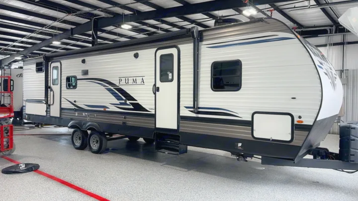 White and gray Puma travel trailer, a spacious camper perfect for your next rv rental adventure, shown indoors.. Palomino 28bhss 2020