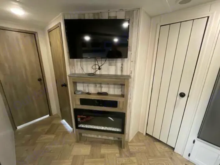 Modern rv rental interior featuring a TV, media console, and electric fireplace for cozy stays.. Palomino 28bhss 2020