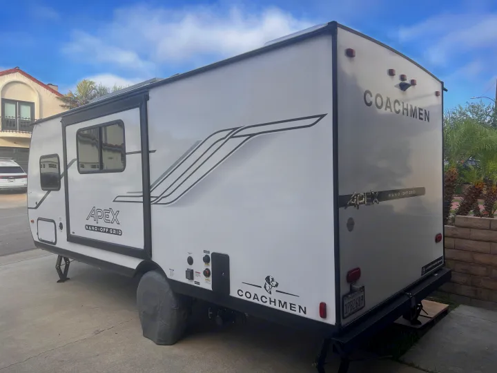 White Coachmen Apex Nano off-grid travel trailer, ideal for rv rental adventures, parked on a concrete driveway.. Coachmen Apex Nano 194BHS 2026
