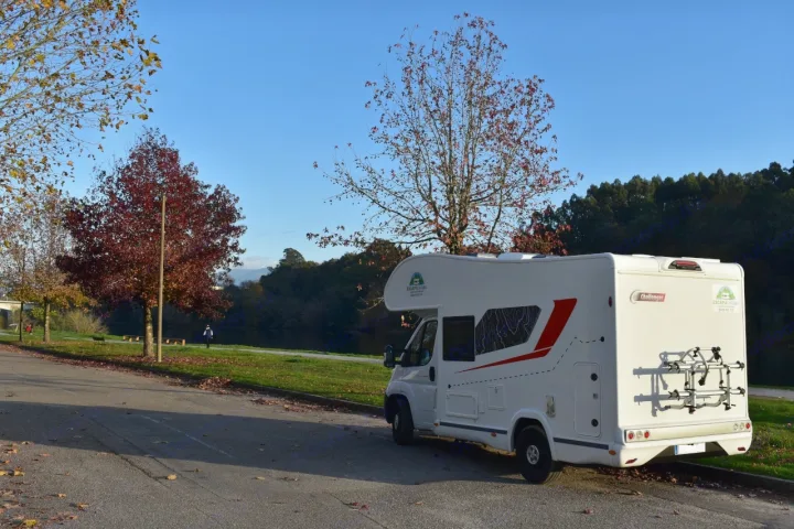 White rv rental campervan parked on an asphalt road next to a park with autumn trees and a river, under a bright blue sky.. CHALLENGER C194 START EDITION 2026