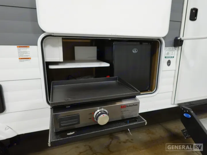 RV rental outdoor kitchen featuring a pull-out Suburban griddle, mini-fridge, and storage for convenient camping meals.. Forest River Wildwood X-Lite 28VBXL 2026
