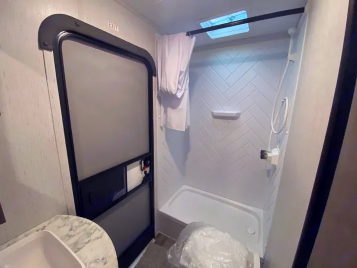 RV rental interior: This compact bathroom features a stand-up shower, a sink, and the main RV exit door.. Coleman Lantern 2021
