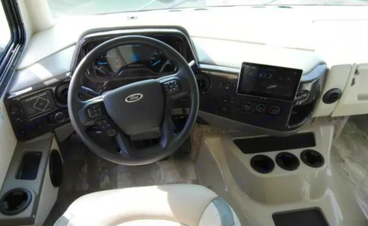 Modern RV rental driver's dashboard with Ford steering wheel, digital displays, and integrated infotainment screen.. Thor Challenger 2023