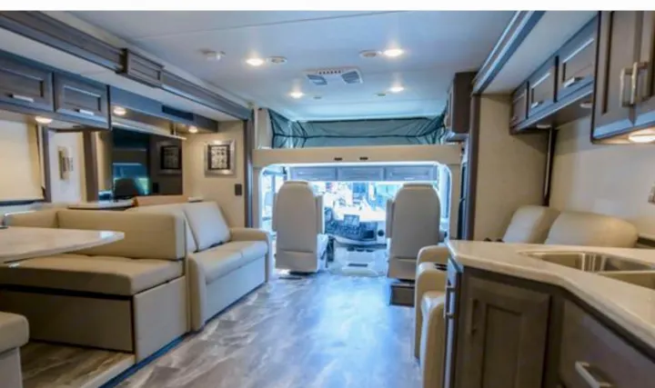 Spacious RV rental interior with modern kitchen, living area, and an overhead bunk bed for comfortable travel.. Thor Challenger 2023