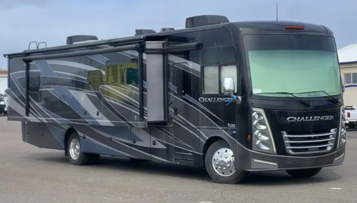 Sleek black Thor Challenger RV rental, a spacious motorhome for your next adventure. Features modern graphics and multiple slide-outs.. Thor Challenger 2023