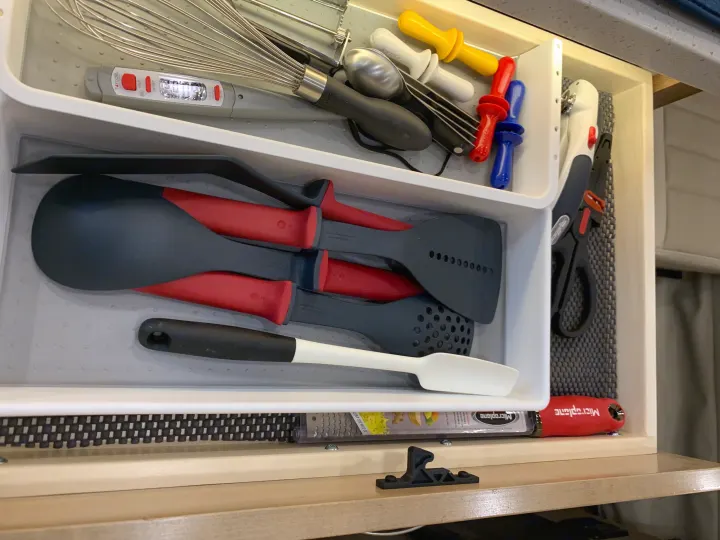 Organized RV rental kitchen drawer with cooking essentials: whisk, spatulas, thermometer, grater, and other handy utensils.. Coachmen Galleria 2020