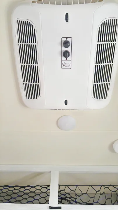 RV rental interior: A white Coleman Mach AC unit on the ceiling with manual controls, air vents, and lower storage net.. Forest River Rockwood Geo Pro 2018