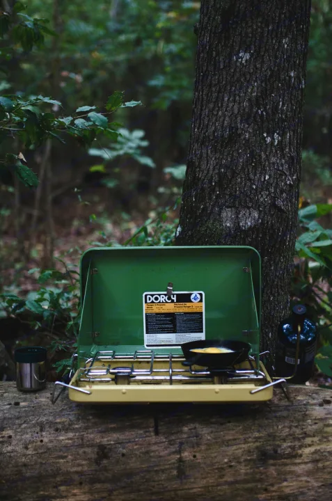 RV rental adventure: Cooking breakfast on a Dorcy propane stove in the forest, surrounded by nature.. Glacier Campers Cosy CrewVan 2015