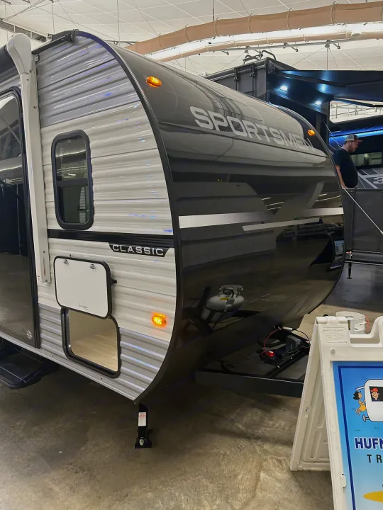 A sleek, two-tone Sportsmen Classic travel trailer, an excellent rv rental option, displayed in a bright showroom.. K-Z 130RD 2026