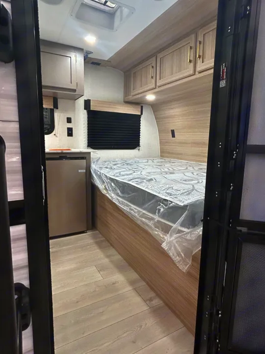 This rv rental features a compact interior with a bed, mini-fridge, and overhead storage. Perfect for road trips and travel.. K-Z 130RD 2026