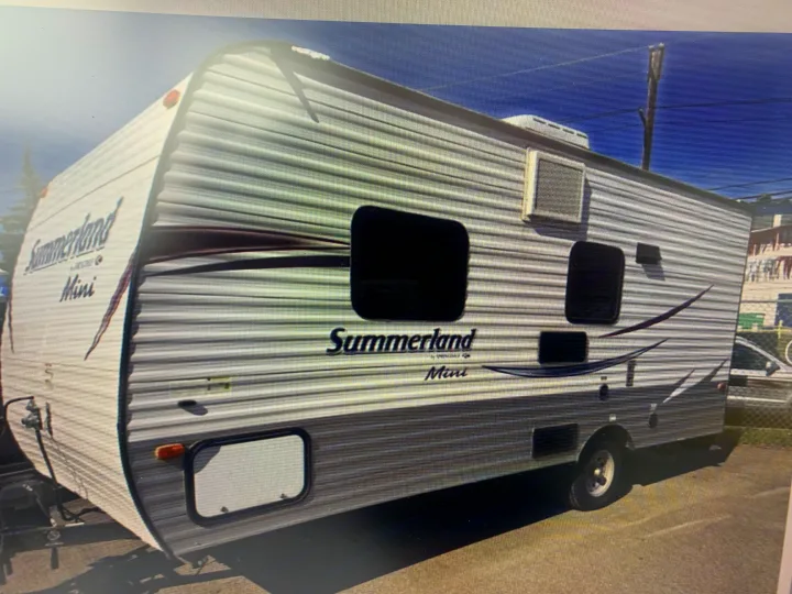 This Summerland Mini travel trailer, a compact RV perfect for rental, features a light, corrugated exterior.. Springdale Sumerland mini 2015