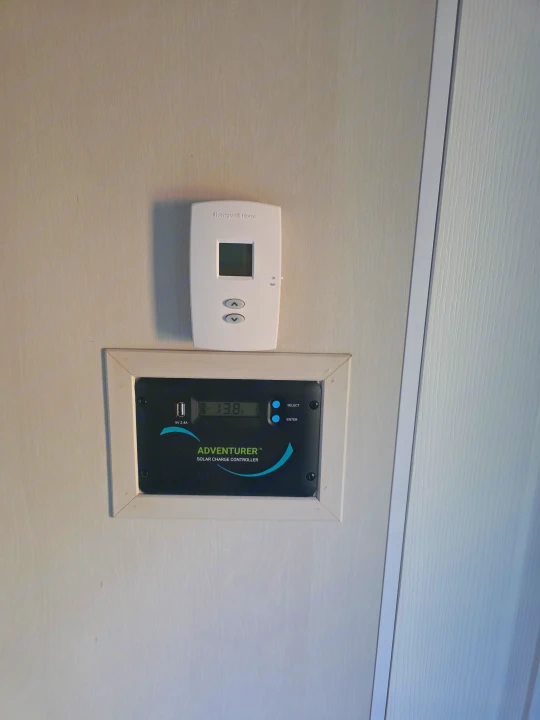 Inside an **rv rental**: Honeywell Home thermostat and Adventurer solar charge controller (13.8V, USB 5V 2.4A).. Dune Sport Dynamite 2023