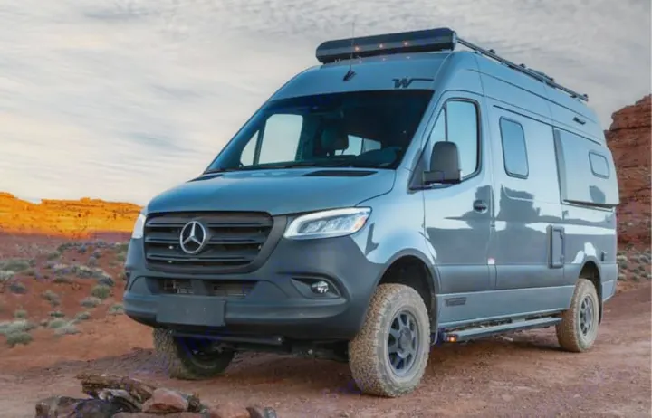 Adventure-ready gray Mercedes Sprinter camper van, with off-road tires and rooftop gear, perfect for your RV rental.. Winnebago Revel 2023