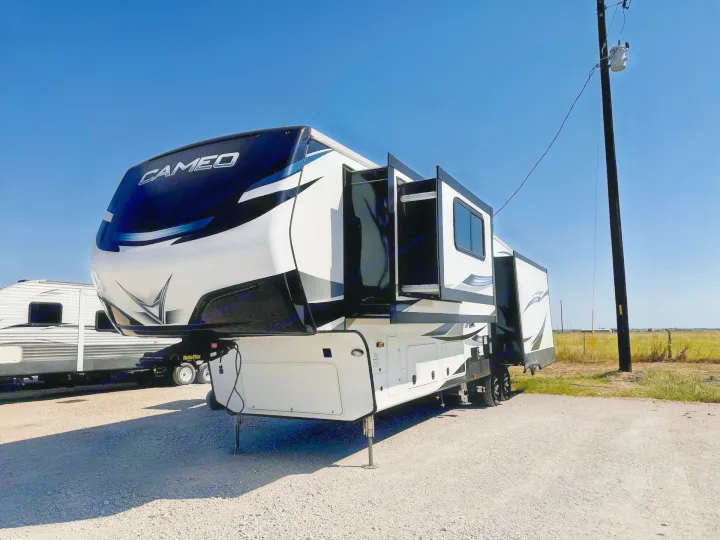 Modern Cameo fifth-wheel RV rental with extended slide-outs, offering ample space for your next outdoor adventure.. Crossroads RV Cameo 2021