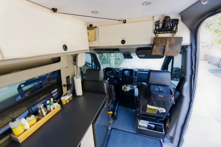 Detailed RV rental interior: custom camper van conversion with cockpit, compact kitchen, and smart storage solutions for travel.. Sportsmobile 2500 2017