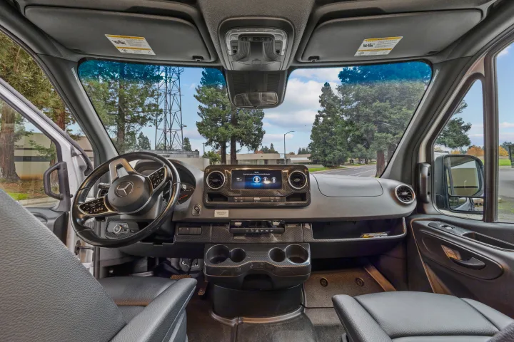 Modern Mercedes-Benz Sprinter van interior, driver's view. Ideal for an rv rental, featuring a sleek dashboard and comfortable seating.. Winnebago Revel 2023