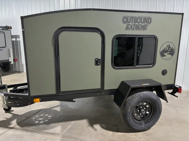 Olive green "Outbound Extreme" adventure trailer, featuring a side door and window. Perfect for an RV rental, ready for travel.. Outbound Trailer Outbound Extreme 2026
