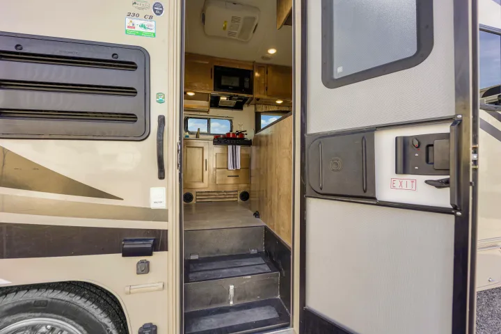 Explore the cozy interior kitchen and steps of this RV rental, visible through its open entrance door.. Coachmen Leprechaun 2021