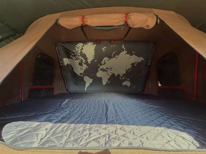 Inside a rooftop tent for your rv rental adventure: quilted mattress, world map, and cozy setup for travel.. Toyota 4Runner 2017