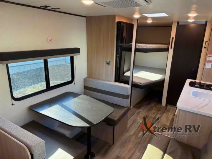 Spacious RV rental interior featuring a dinette, bunk beds, and a functional kitchen area, ideal for family travel.. Open Range Open Range 2026