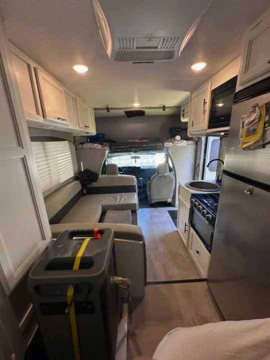 RV rental interior showcasing a full kitchen, comfortable dinette seating, & a portable power unit. Ideal for road trip comfort.. Coachmen Crosstrek 23XG 2021