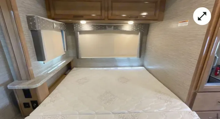 Cozy rv rental bedroom: bed, window shades, overhead cabinets, and charging shelf. Ready for your adventure.. Thor Quantum 2021