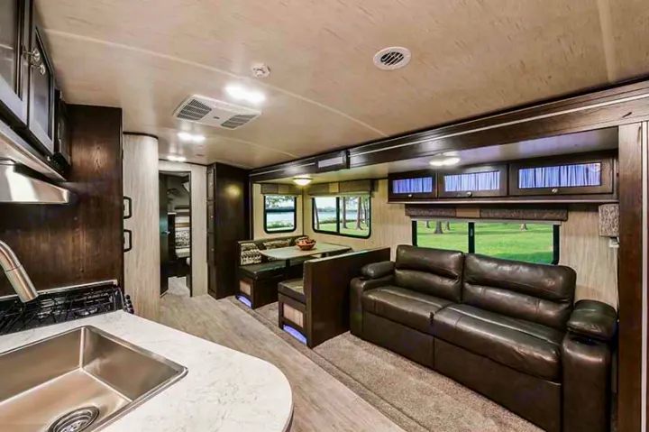 Explore this modern RV rental interior featuring a well-appointed kitchen, comfy dining area, and spacious living room sofa.. Cruiser RV Shadow Cruiser 2019