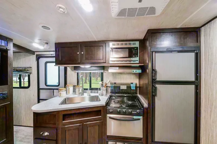 This RV rental offers a modern, fully-equipped kitchen with a sink, stove, microwave, and fridge for comfortable travel.. Cruiser RV Shadow Cruiser 2019