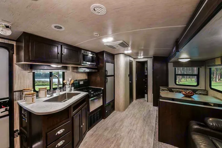 This modern RV rental interior features a fully equipped kitchen, dining area, and living space for comfortable travel.. Cruiser RV Shadow Cruiser 2019