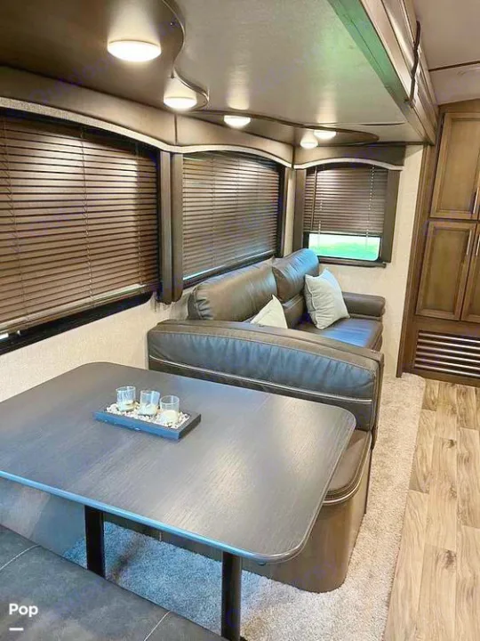 RV rental: Cozy interior featuring a dining table with booth seating, a sofa, and overhead lighting.. Keystone RV Cougar 2021