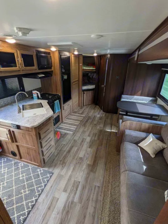 Modern RV rental interior: kitchen, dinette, sofa, and bunk beds. Perfect for family adventures and comfort on the road.. Jayco Jay Feather 2019
