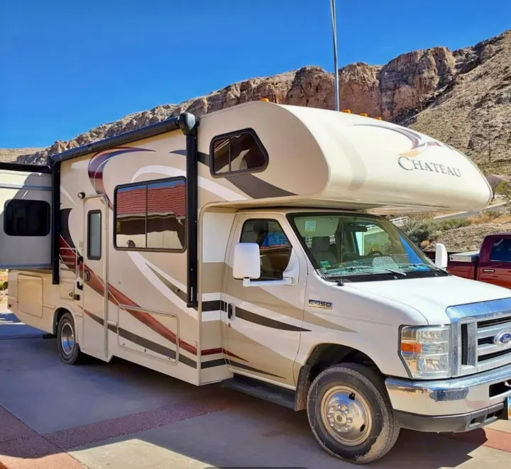 Ready for your next adventure: a spacious Class C rv rental with slide-out, parked against a stunning mountain backdrop.. Thor Chateau 2016