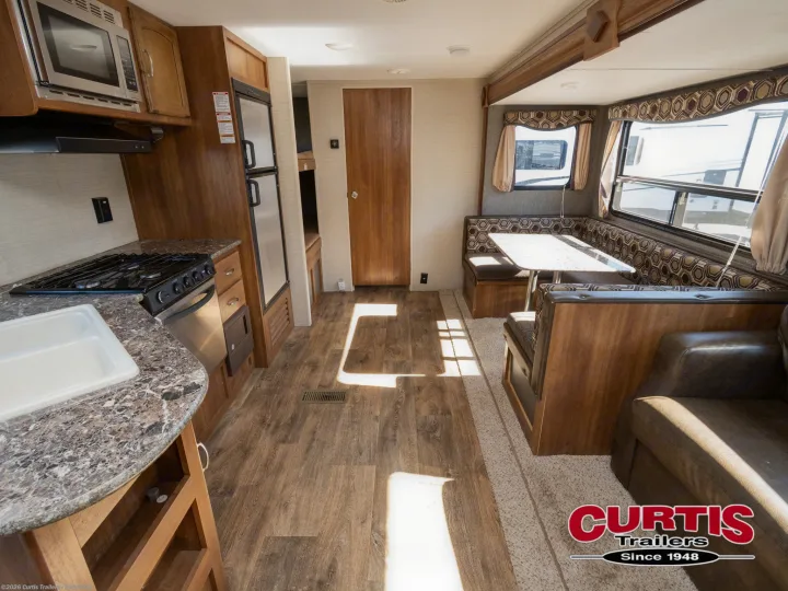 RV rental interior featuring a full kitchen, dinette, sofa, and wood flooring. Bright and spacious.. Springdale sm2820bh16 2016