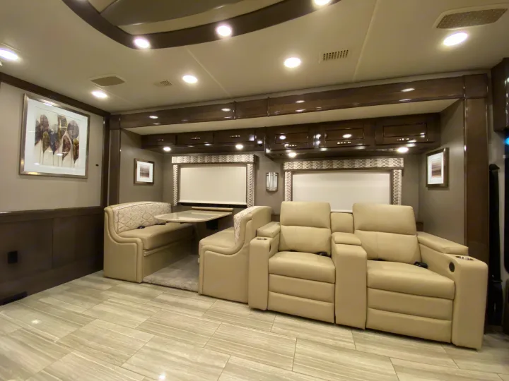 Luxury RV rental interior: recliners, dining booth, and storage offer a comfortable and modern living space.. Entegra Coach Reatta 2021