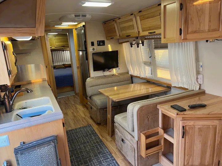 Cozy RV rental interior: kitchen, dinette, fridge, and bedroom view. Ideal for your next road trip adventure.. Airstream Classic 2012