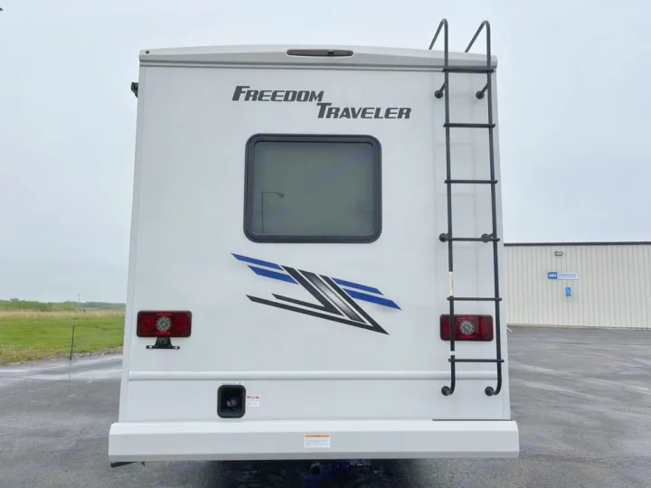 Back of a white Freedom Traveler RV rental, featuring a ladder, rear window, and bright taillights for your journey.. Thor Freedom Traveler 2025