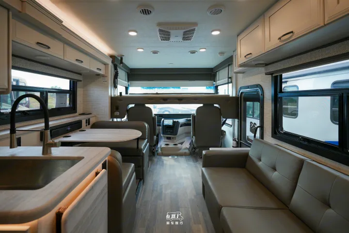 Spacious RV rental interior with a functional kitchen, comfortable dinette, sofa, and an overhead bunk, ready for travel.. Jayco Travel Supreme A Series 27A 2025