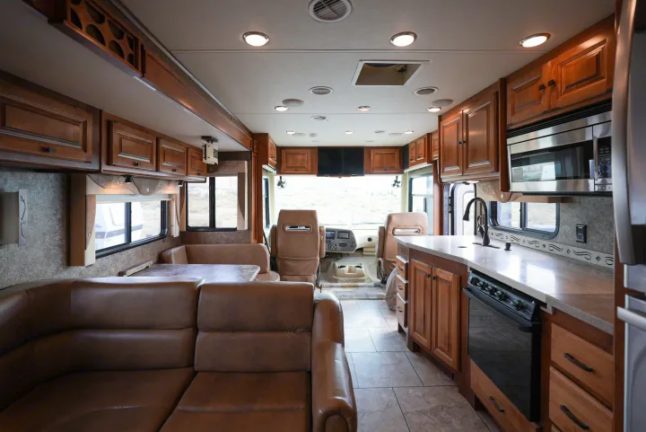 Explore this spacious RV rental interior! Features a full kitchen, cozy dining booth, sofa, and driver's cockpit.. Allegro Allegro Motorhome 2014