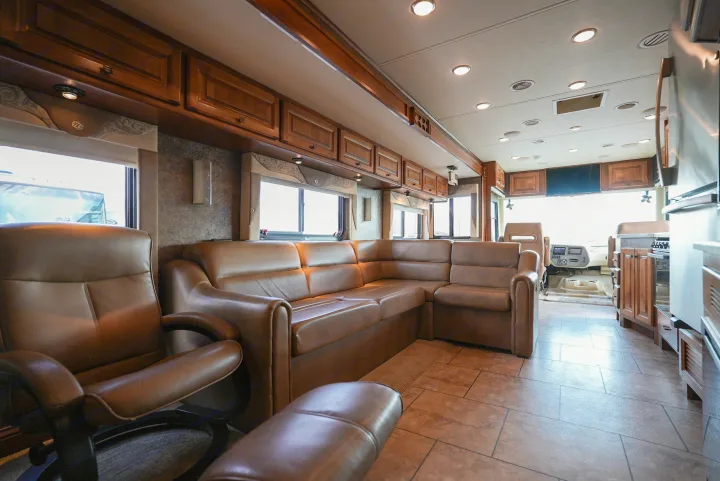 Step into this modern rv rental. A luxurious motorhome living area with brown leather seating, wood cabinets & tiled floor.. Allegro Allegro Motorhome 2014