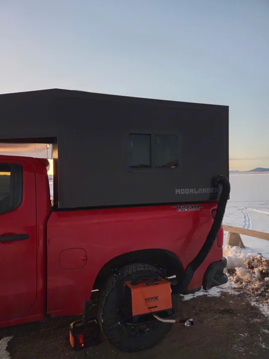Red pickup with a black Moonlander truck camper, Vevor heater, and Jackery power in snow. Perfect for an RV rental adventure.. Chevrolet Silverado 1500 Trail Boss 2020